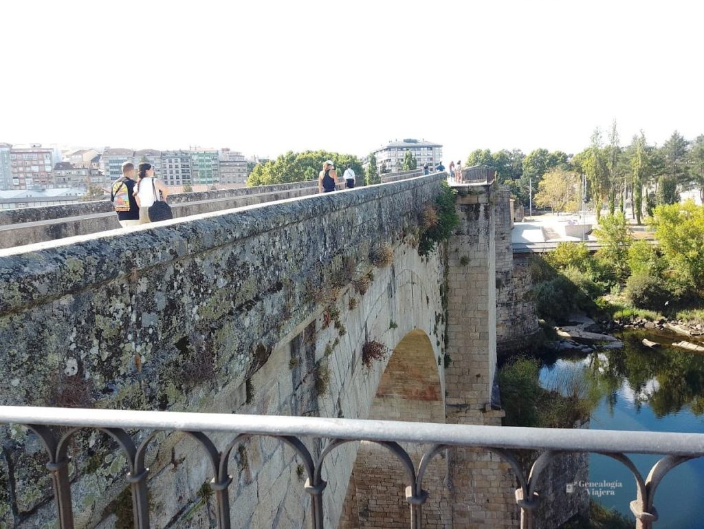 Gente crizando por el puente romano en Ourense