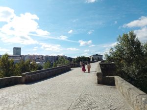 Gente caminando sobre el puente romano en Ourense