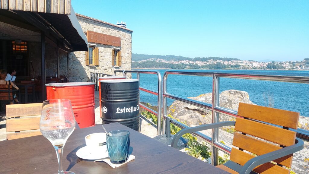 Terraza frente al mar en Combarro con un tonel decorativo de Estrella Galicia y vistas a la ría de Pontevedra.