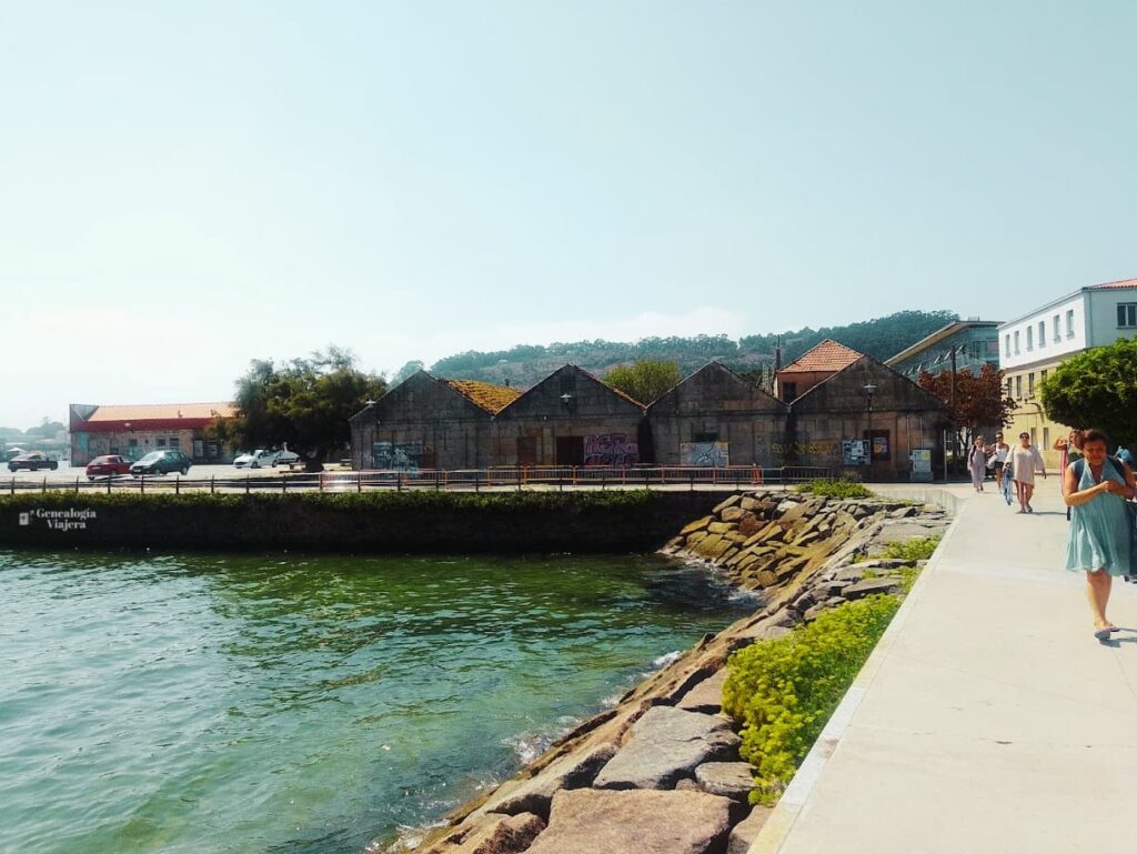 Paseo marítimo de Cangas do Morrazo junto a la ría de Vigo, con caminantes y aguas de tonos verdosos al final de la tarde.