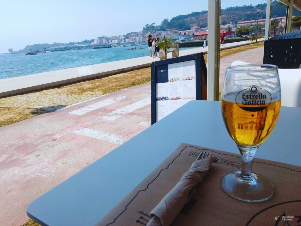 Mesa frente al mar en Cangas do Morrazo con una caña y cubiertos preparados para el almuerzo.