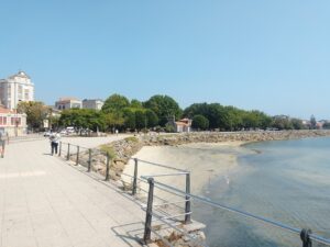 Paseo costero de Cangas do Morrazo bordeando la playa y el mar de aguas turquesas.