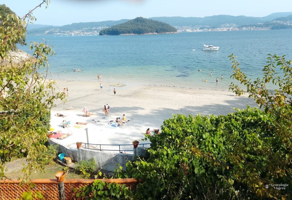 Vista de la playa de Chancelas entre la vegetación, con la isla de Tambo al fondo.