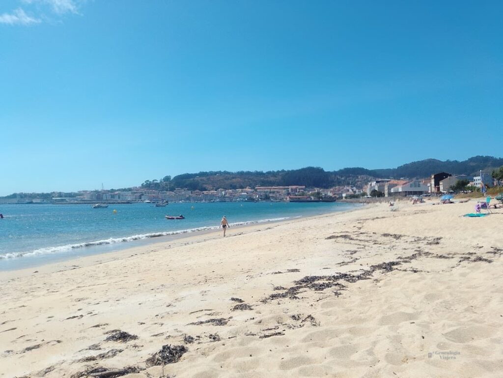Playa de Cangas do Morrazo con amplia franja de arena clara, aguas azules y pocos visitantes.