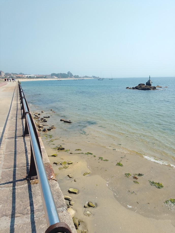 Vista de la ría de Vigo desde el paseo marítimo de Cangas do Morrazo, con aguas de color turquesa.