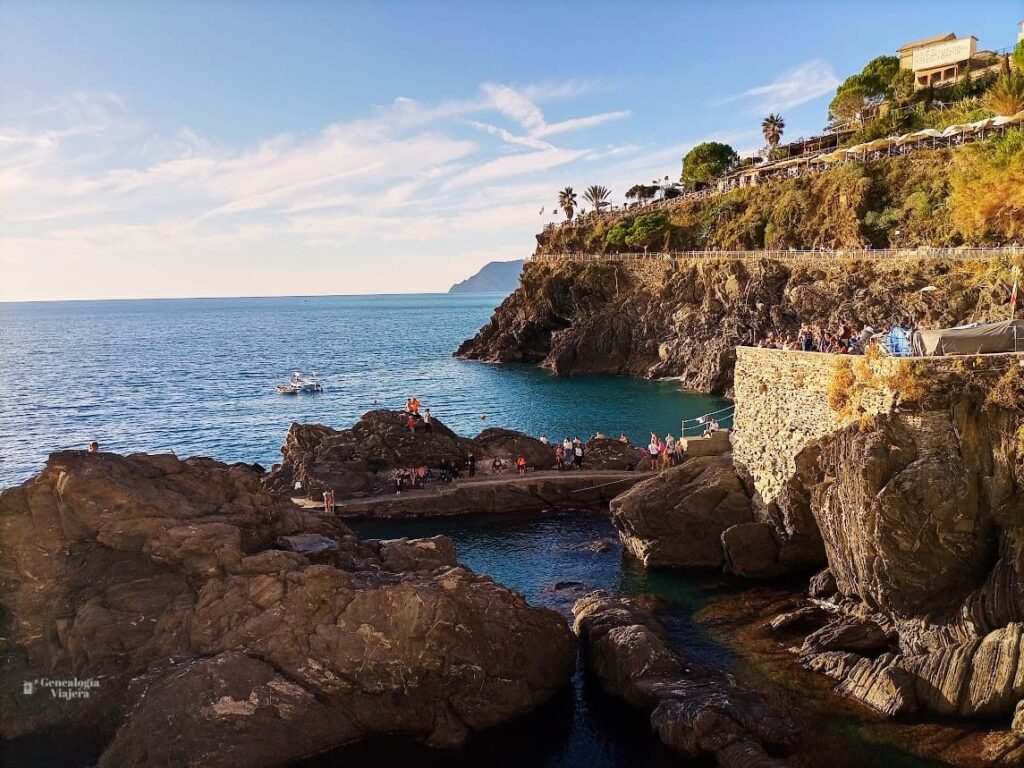 Zona de baño en el puerto sin playa de arena, rodeada de grandes rocas y acantilados. El famoso mirador y bar Nessun Dorma en la parte alta del acantilado. 