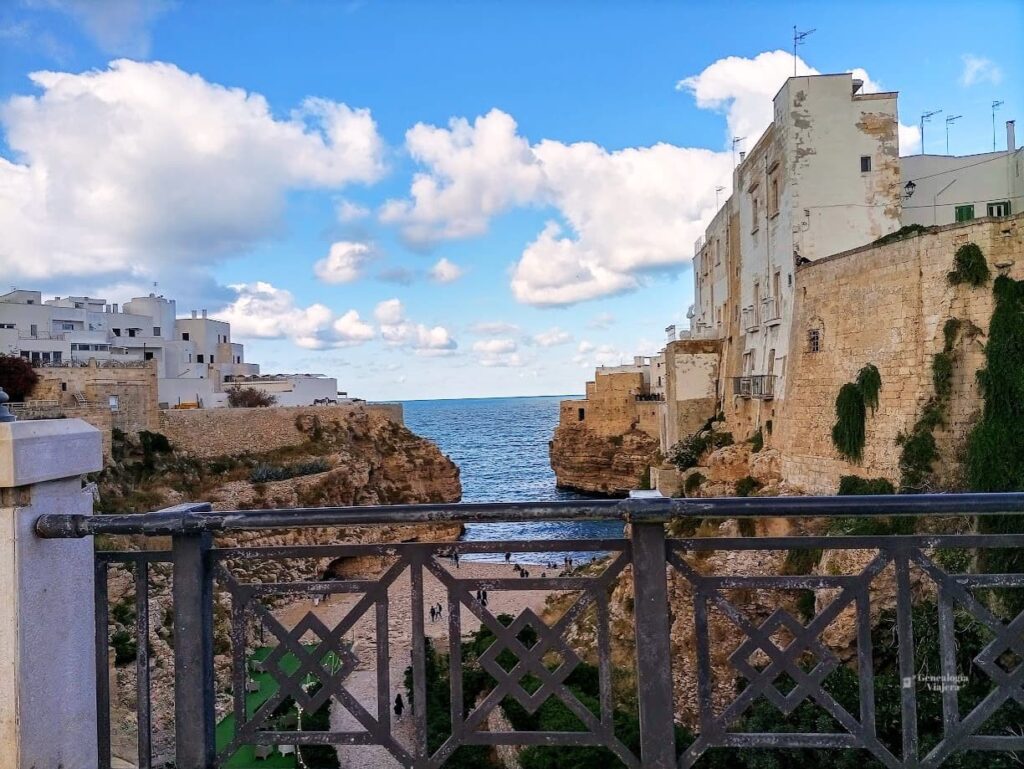 Vista de Cala Porto o Lama Monachile desde el puente de Polignano a Mare al final de la tarde, con el mar Adriático y los acantilados de fondo