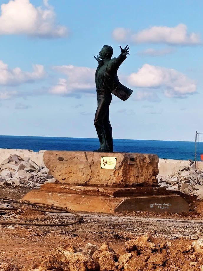 Estatua de Domenico Modugno, cantante de Volare, en Polignano a Mare con vistas al mar Adriático