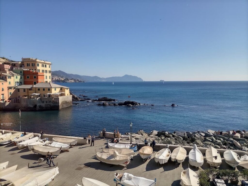 Explanada con numerosos botes de pesca en Boccadasse, el histórico barrio marinero de Génova, con el mar Mediterráneo al fondo.