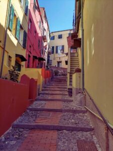 Estrecha calle de piedra con escaleras y edificios de colores en Boccadasse, uno de los barrios más pintorescos de Génova.
