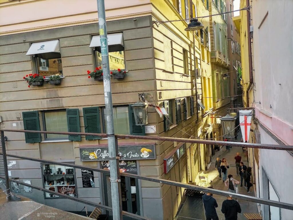 Vista desde un balcón urbano hacia un carruggio del centro histórico de Génova, con las calles escalonadas características de la ciudad.