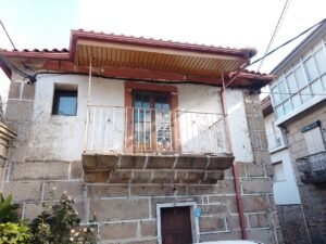 Casa tradicional de piedra con grandes ventanales en San Cibrao das Viñas