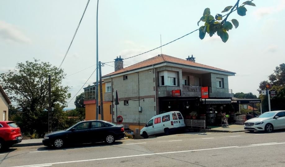Vista panorámica a lo lejos de las fachadas contiguas del supermercado y el bar del pueblo en Sandiás