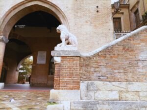 Lateral del Palazzo dell'Arengo en Rimini, con una escalera y una escultura de piedra