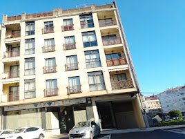 • Edificio de departamentos de varias plantas con amplios ventanales y balcones en una esquina céntrica de O Carballiño.
