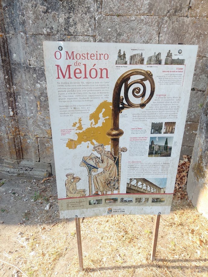 Cartel informativo de color blanco con mapas e ilustraciones históricas titulado O Mosteiro de Melón situado junto a una pared de piedra.