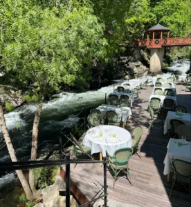 Mesas del restaurante Muiño das Lousas junto al río